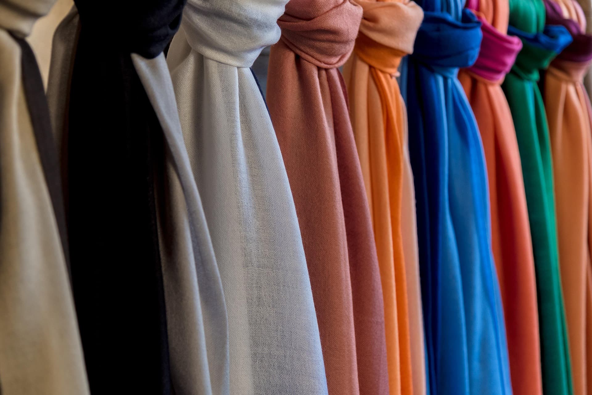 Hand touching a sheer curtain in warm light